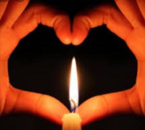 Mains en forme de cœur autour d'une flamme